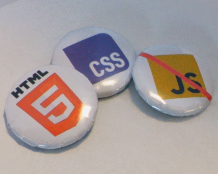 three 25mm buttons (pins). one with a html logo. another with a css logo. the third is a js logo with a red line through it