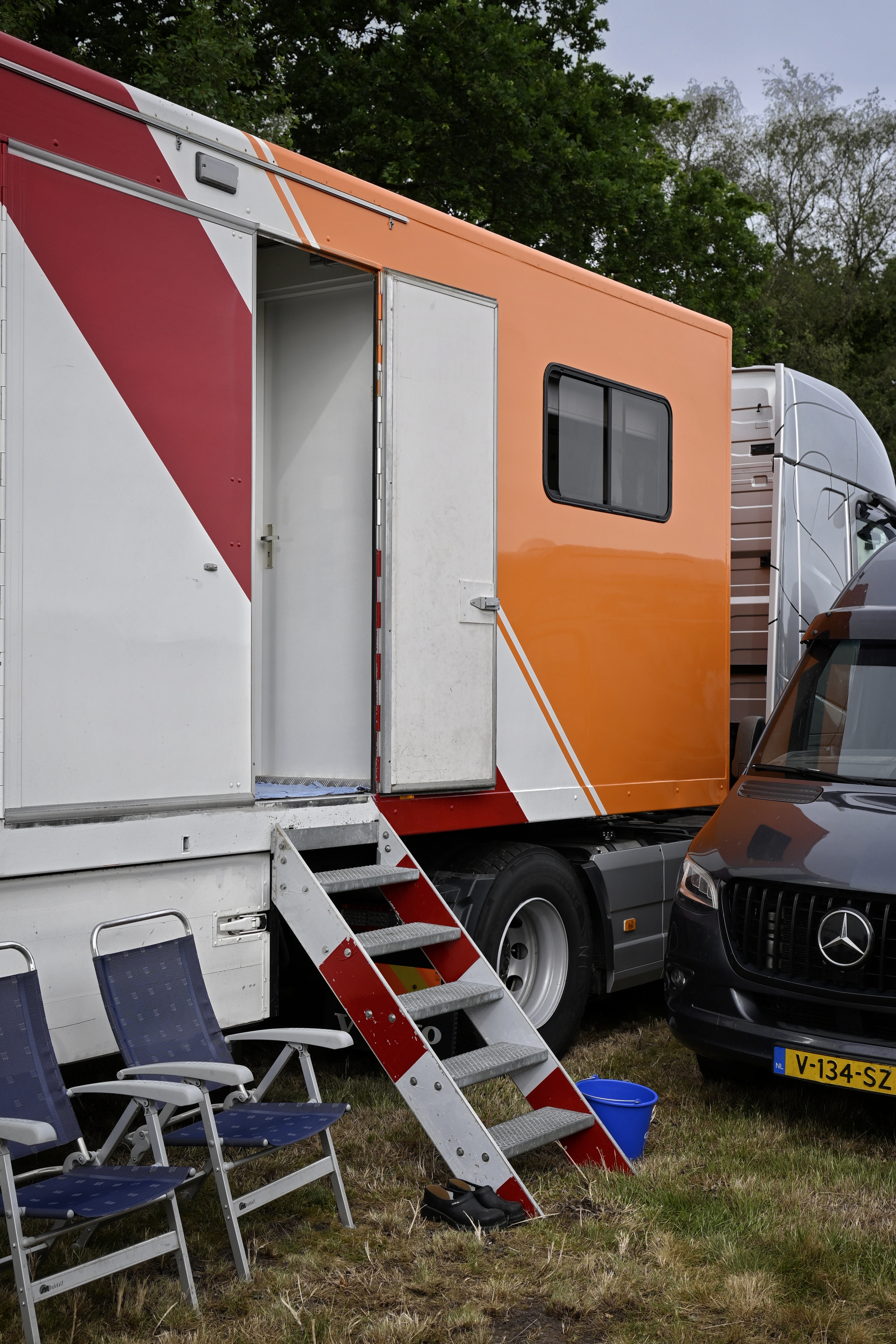 the side of a trailer with a door open. A pair of steps made out of traffic signs connects to it.