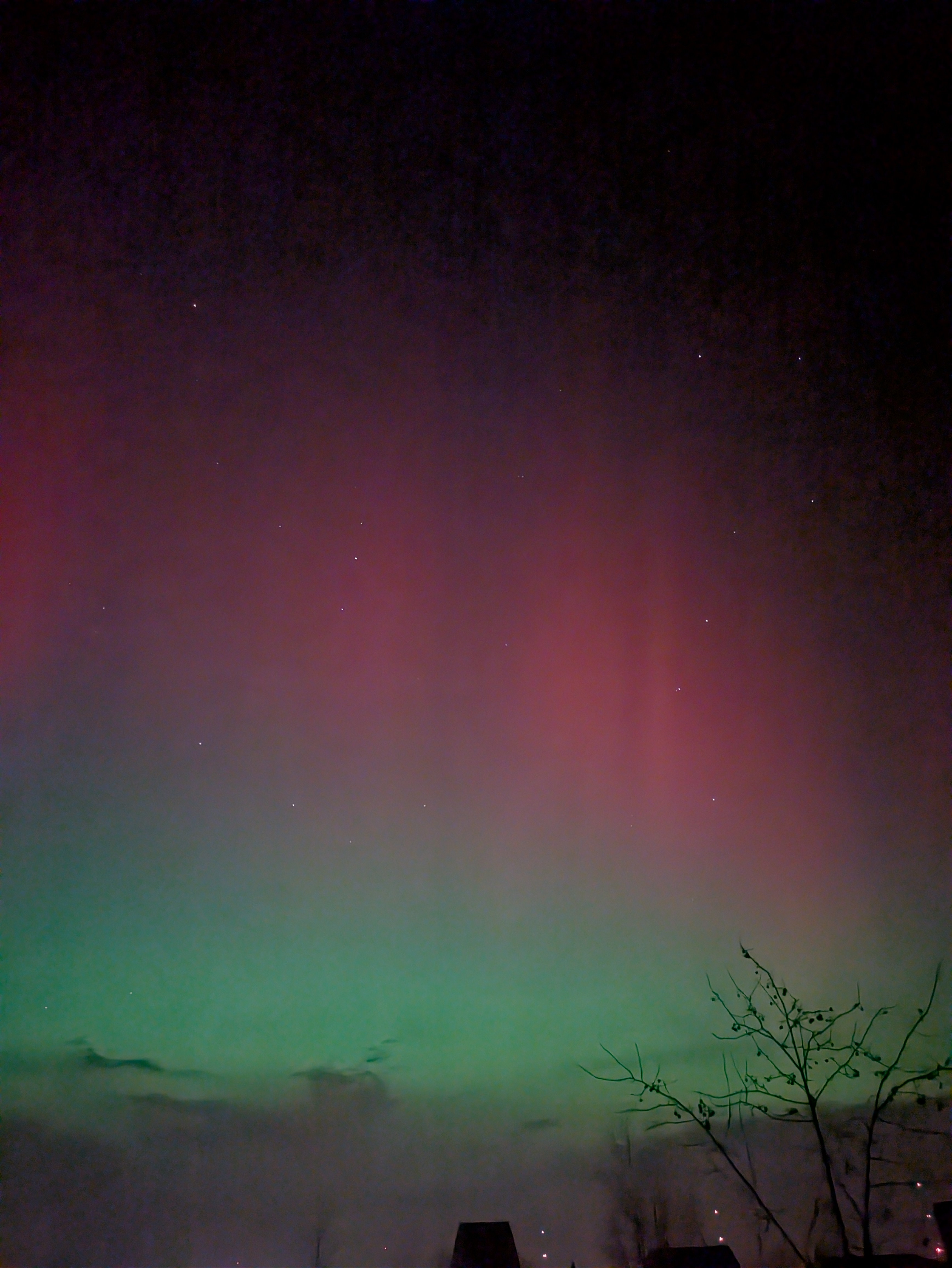 Northern lights in the night sky. Green haze and vertical red striping.