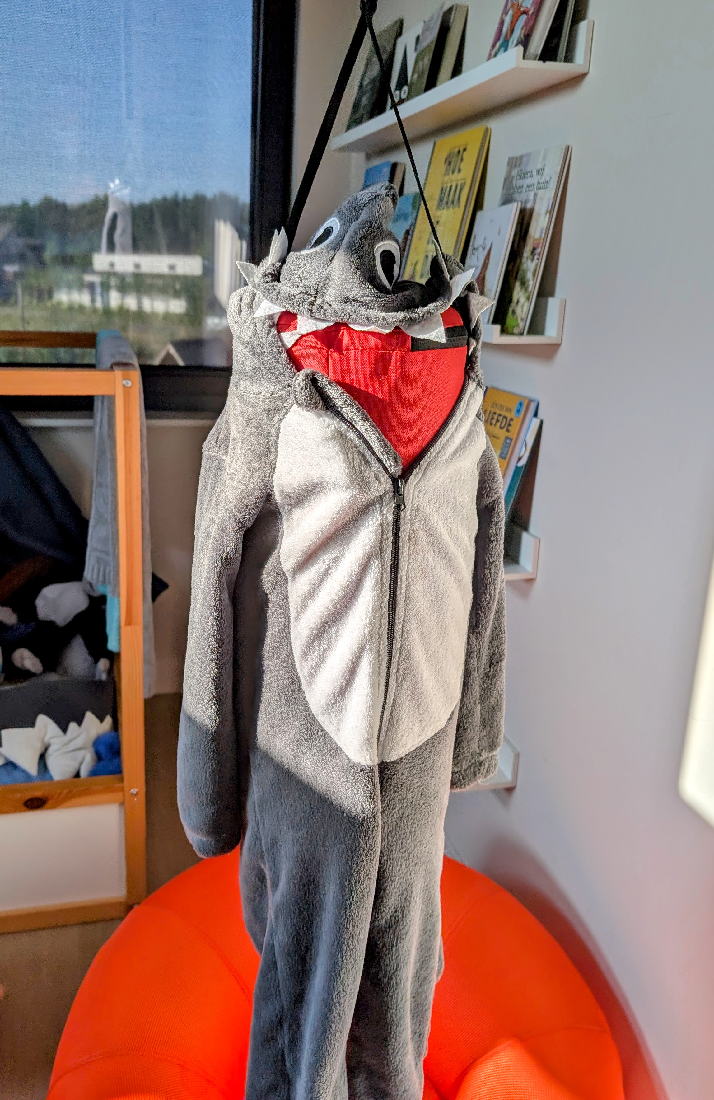 A grey onesie for kids with a bit of a monterous look covering a punching bag